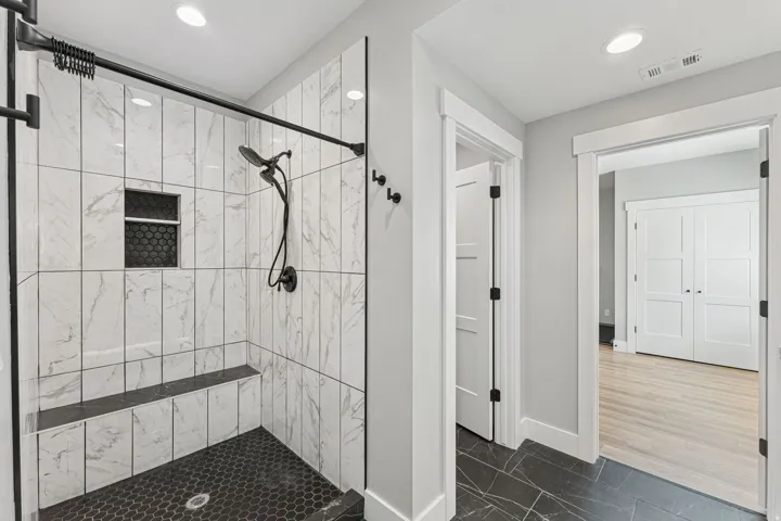 Full bathroom featuring a stall shower, dark marble finish flooring, and recessed lighting