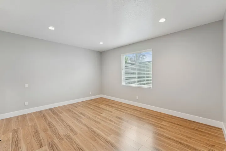 Empty room with light wood finished floors, recessed lighting, and a textured ceiling