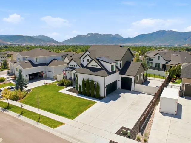 Modern residence featuring a dark-toned roof, white siding, and black trim accents