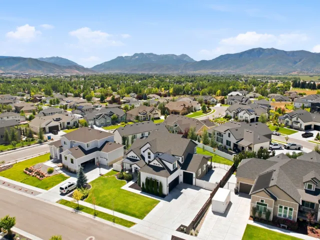 Expansive manicured neighborhood featuring a variety of architectural styles, mature landscaping, and mountain backdrops