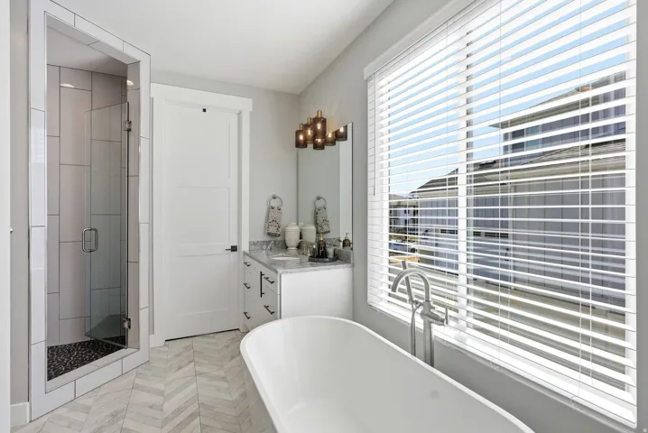 Bathroom featuring vanity, a stall shower, and a freestanding tub
