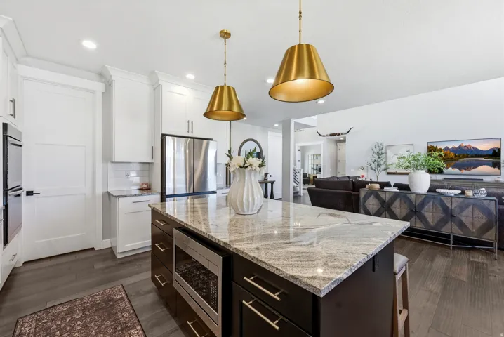 Kitchen featuring a large island with a stone countertop, recessed microwave, and seating