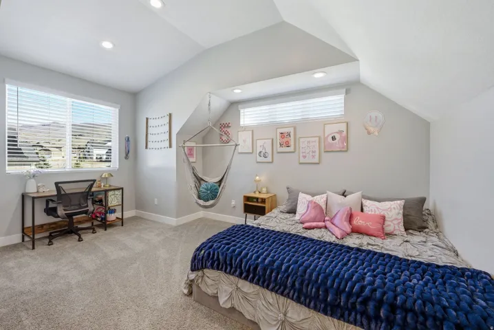 Bedroom with light colored carpet, a desk, and recessed lighting