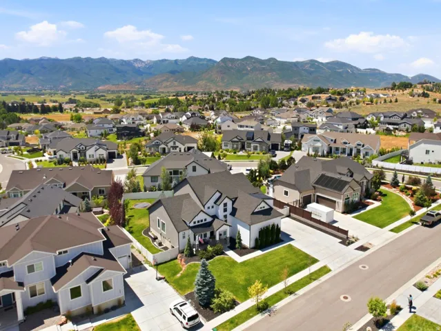 Expansive manicured neighborhood featuring a variety of architectural styles, mature landscaping, and mountain backdrops