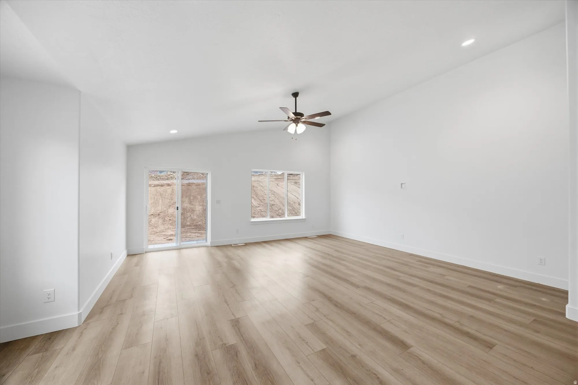 Spare room with recessed lighting, vaulted ceiling, ceiling fan, and light wood finished floors