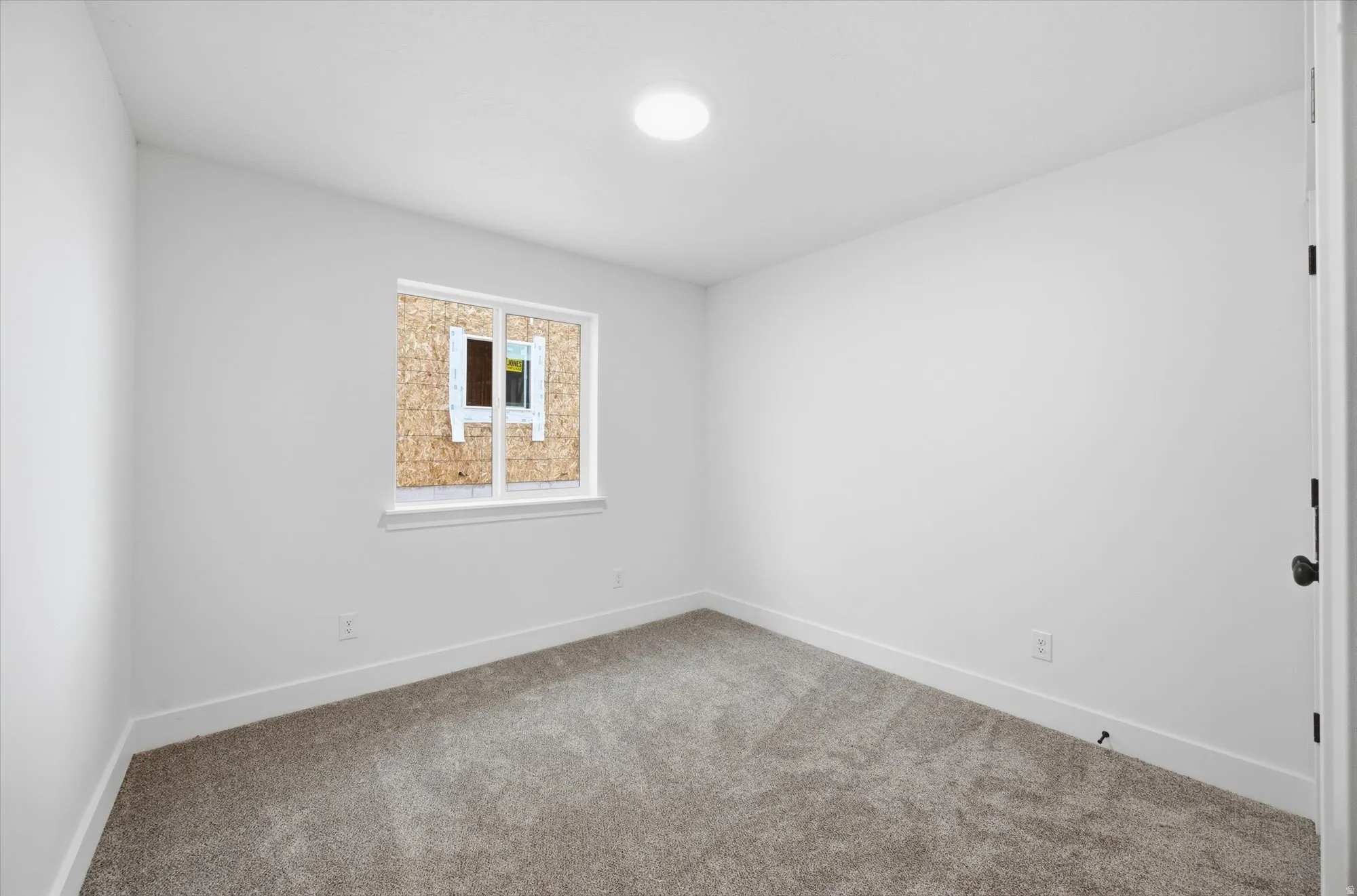 Spare room with baseboards and carpet