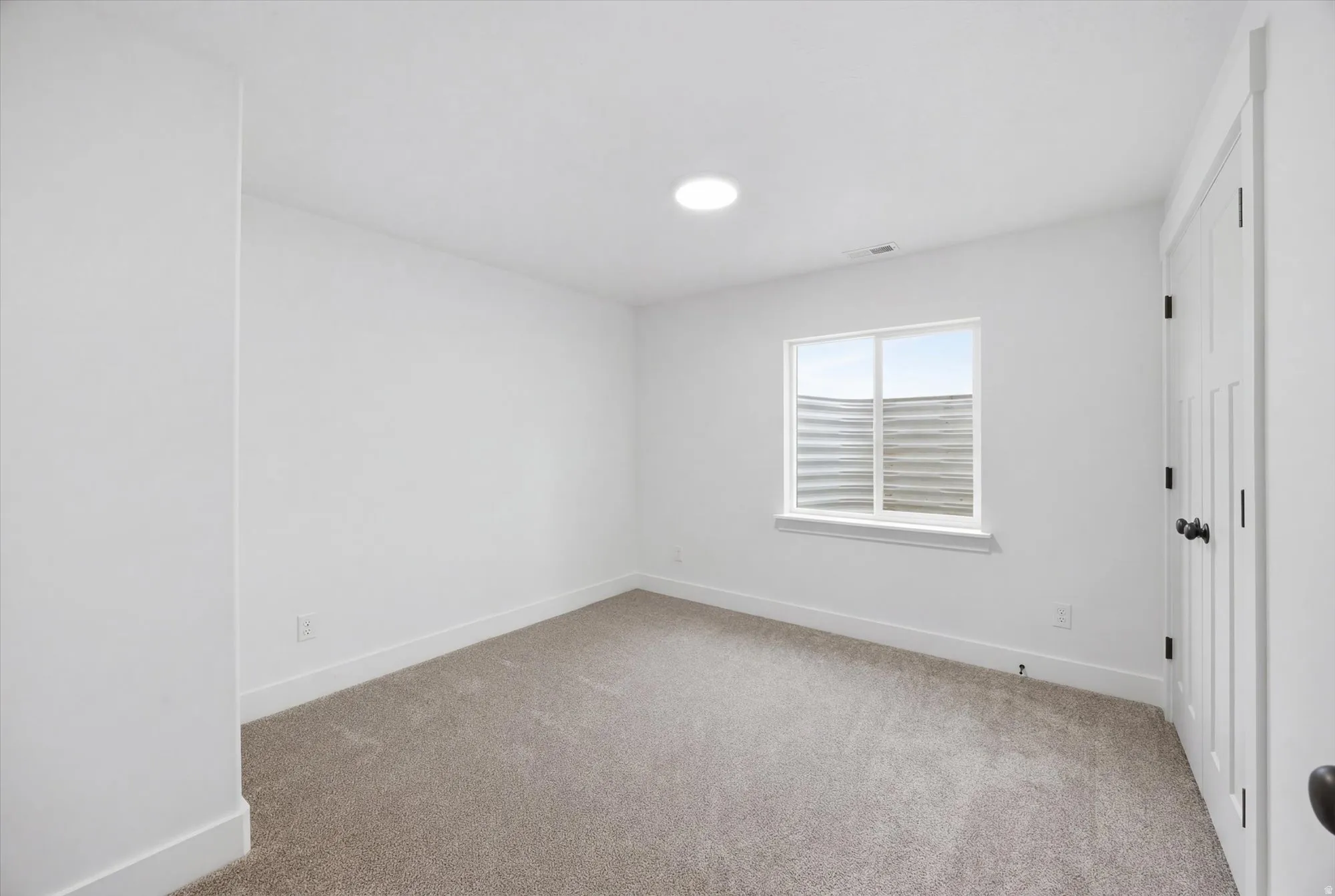 Spare room with light colored carpet and baseboards