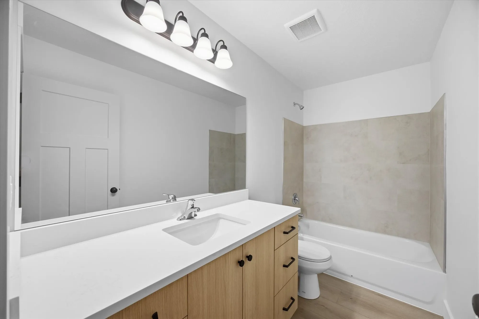 Bathroom with vanity, shower / washtub combination, and light wood finished floors