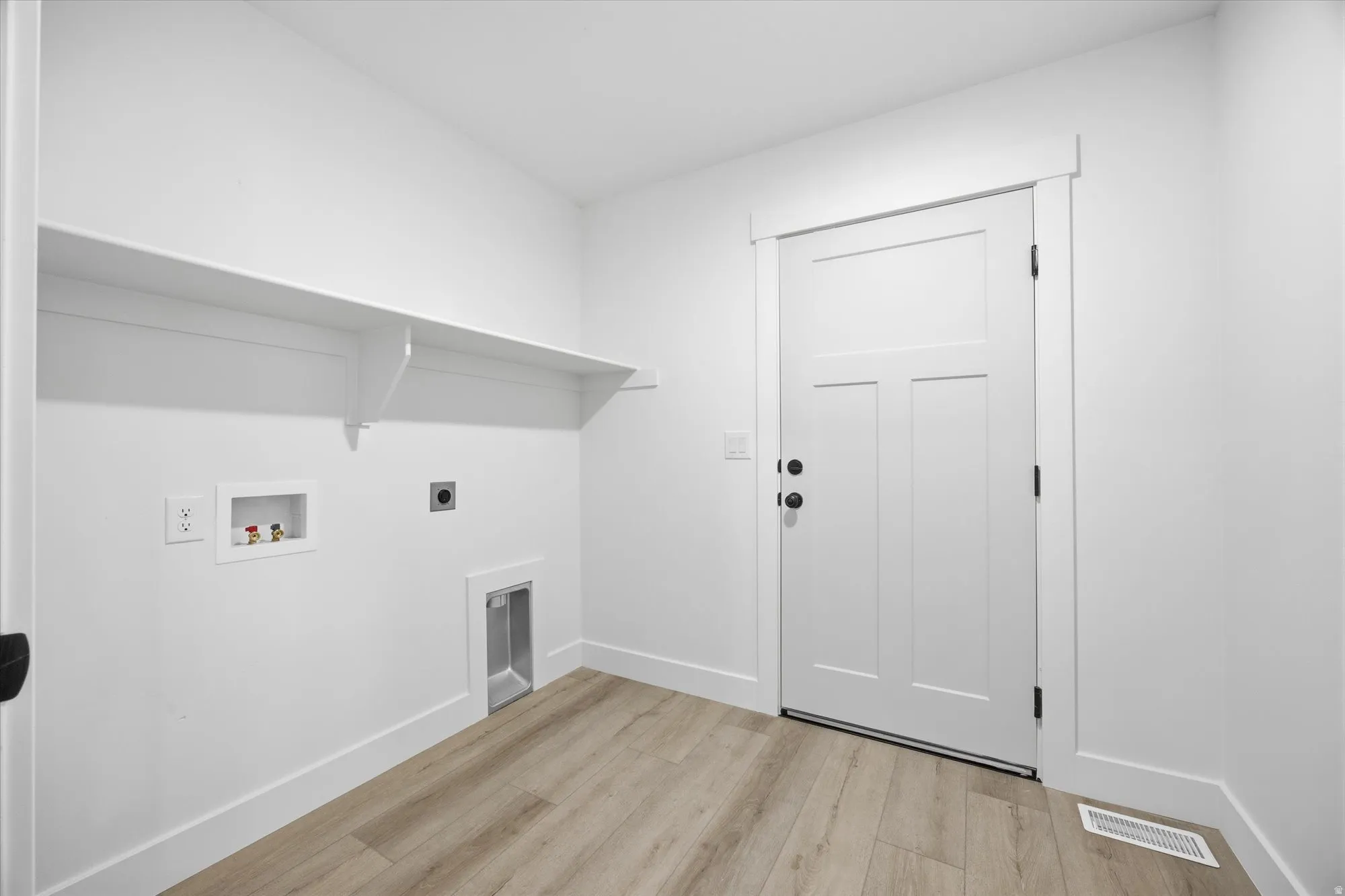 Laundry area featuring light wood finished floors, washer hookup, and hookup for an electric dryer