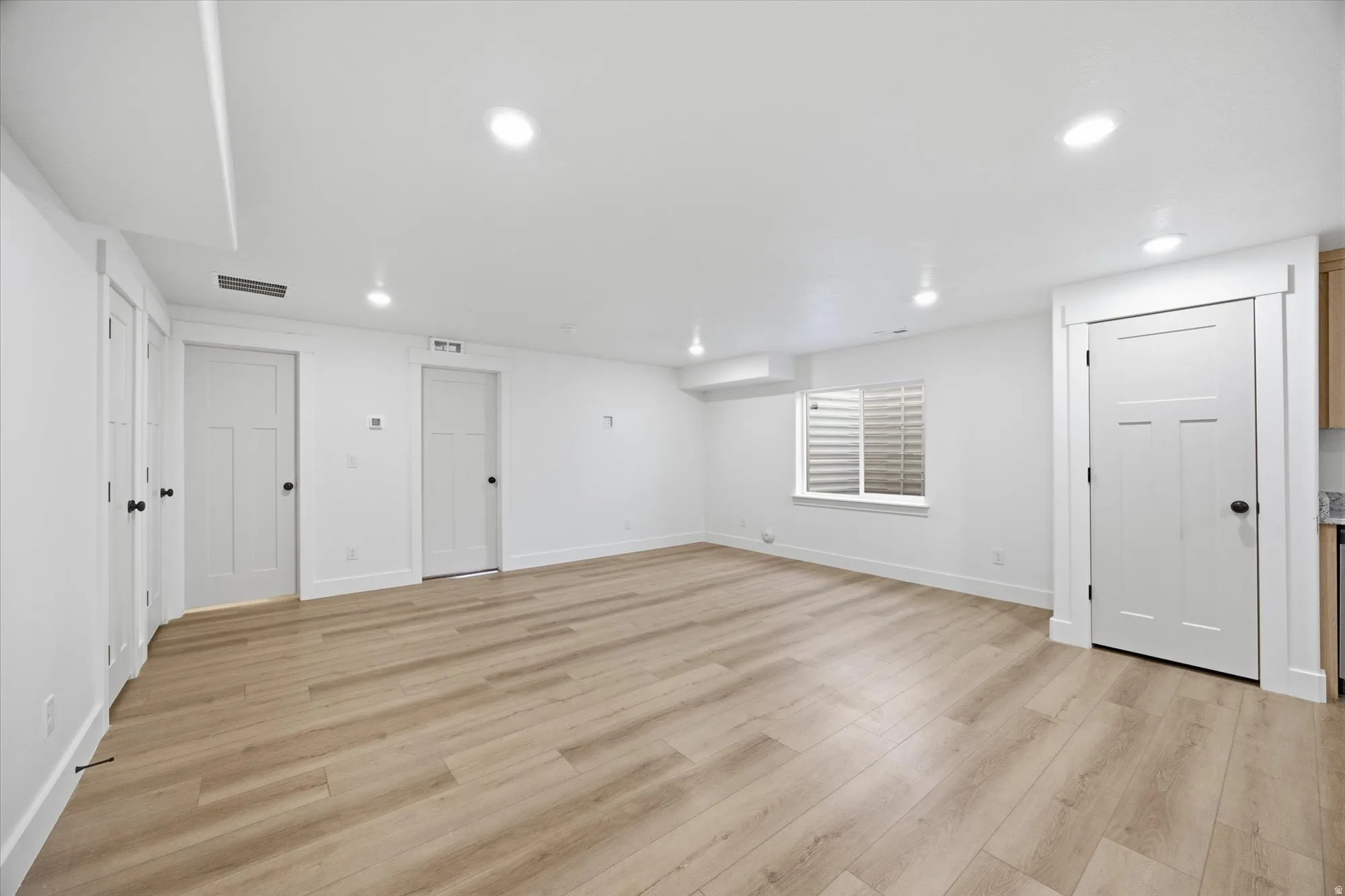 Finished basement featuring light wood-style flooring and recessed lighting