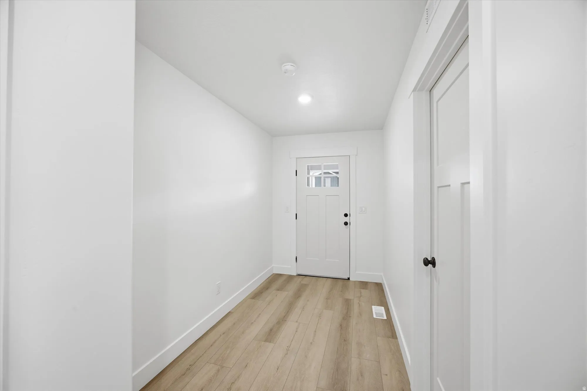 Doorway to outside featuring baseboards and wood finished floors