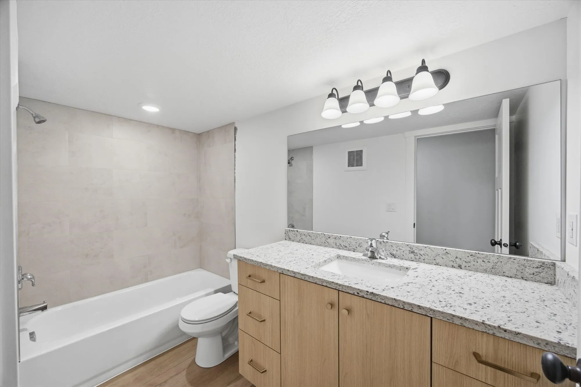 Bathroom with vanity, shower / bathtub combination, light wood-style flooring, and recessed lighting