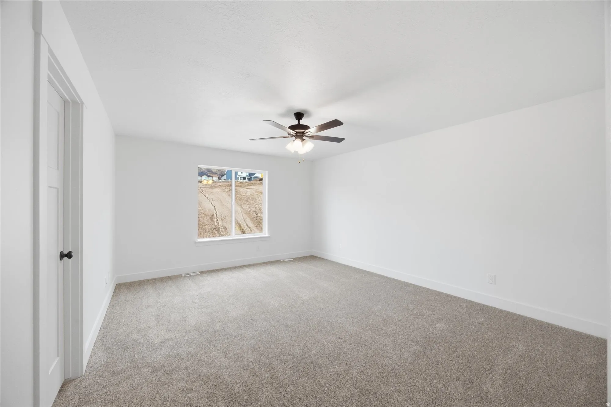 Unfurnished bedroom with light colored carpet and ceiling fan