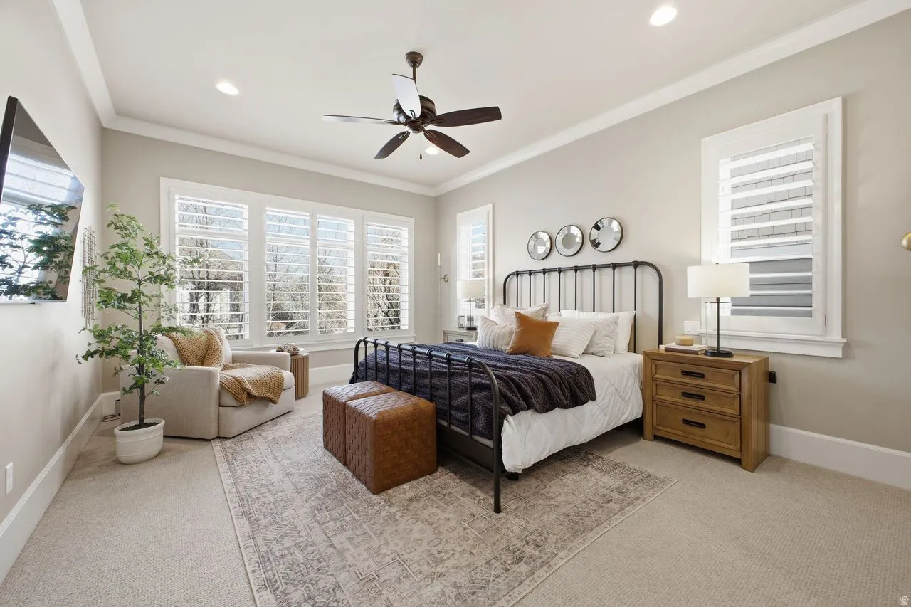 Main Floor Primary Bedroom featuring light carpet, ornamental molding, a ceiling fan, and recessed lighting