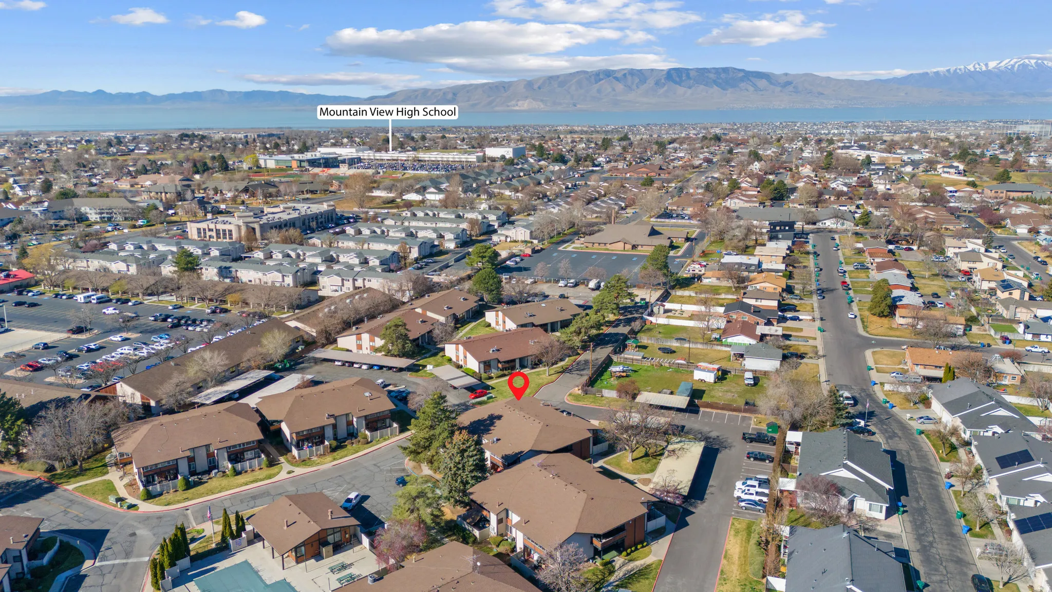 Aerial view of property and surrounding area with mountains and nearby suburban area