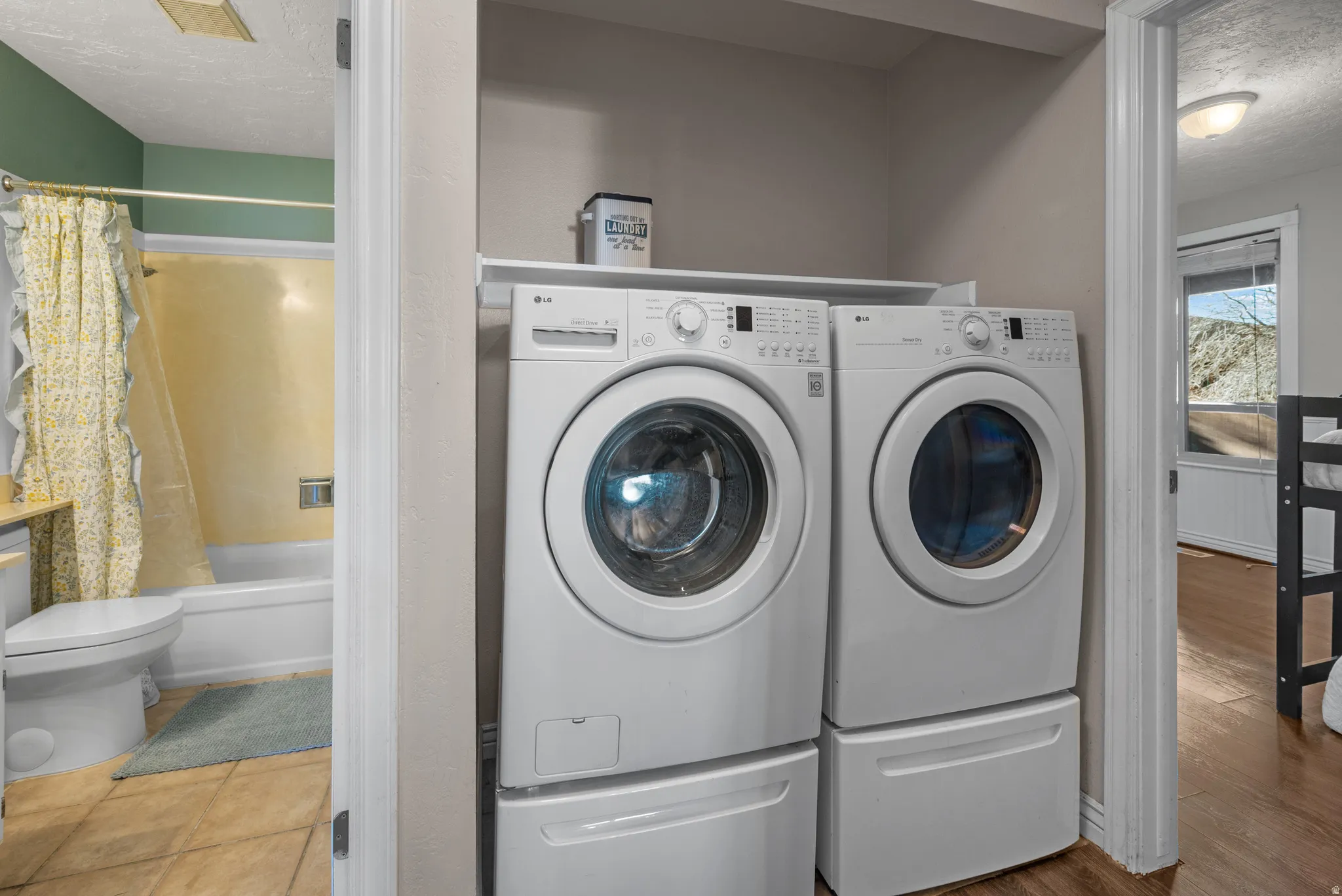 Laundry area with a textured ceiling and independent washer and dryer