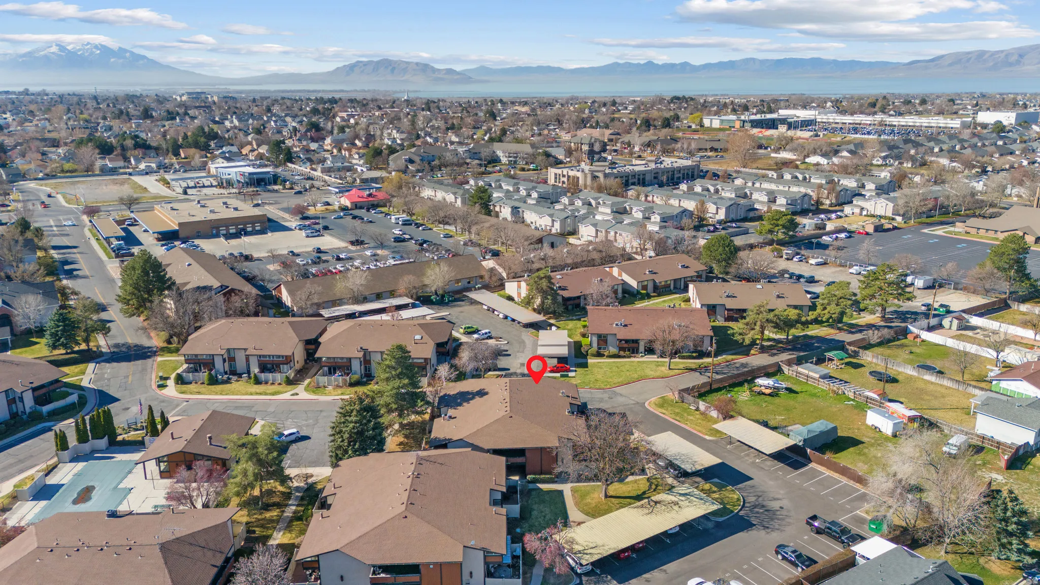 Aerial view of property and surrounding area with a mountain backdrop