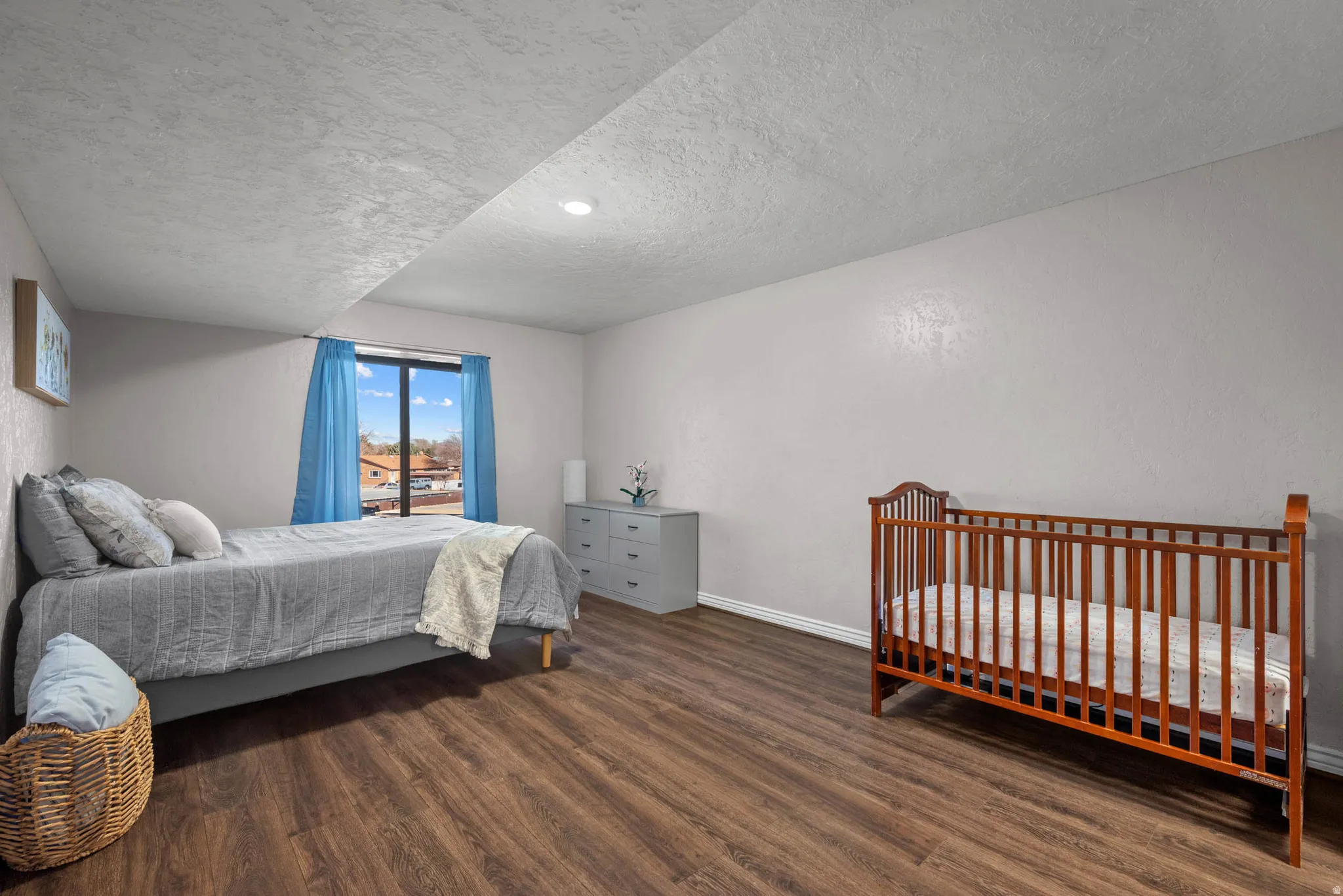 Bedroom with dark wood-style flooring and a textured ceiling