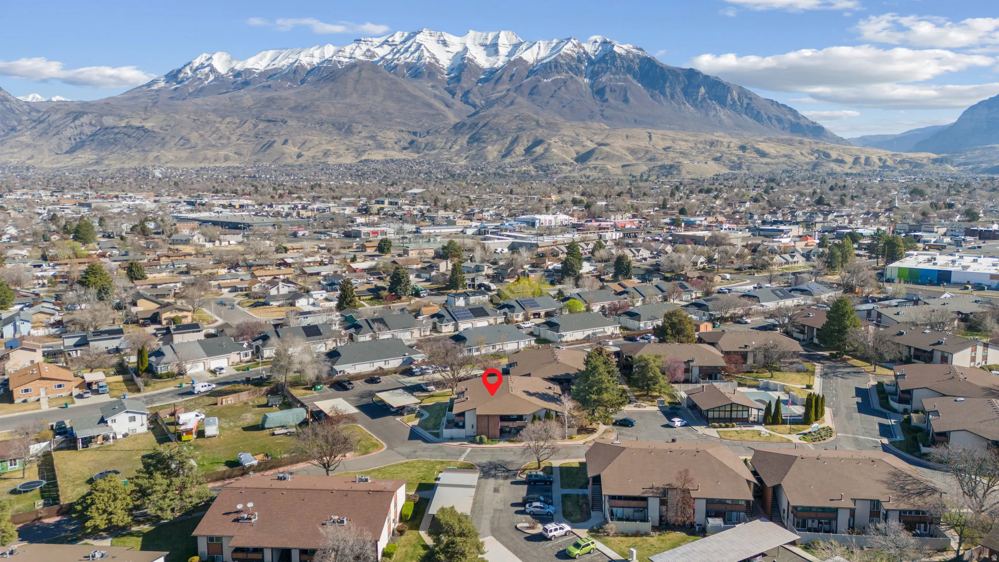 Aerial view of property's location featuring a mountain backdrop and nearby suburban area