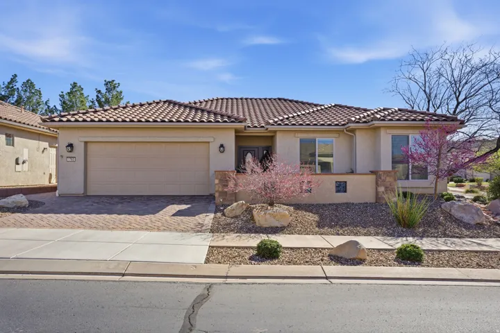 Mediterranean / spanish-style home with stucco siding, a garage, driveway, and a tiled roof