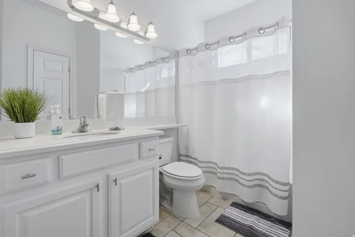 Full bath with vanity, curtained shower, and light tile patterned flooring