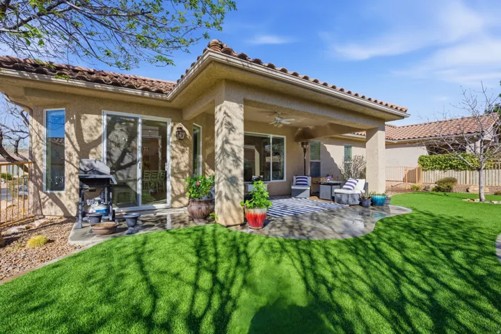 Back of house with a ceiling fan, a patio, stucco siding, and a tiled roof