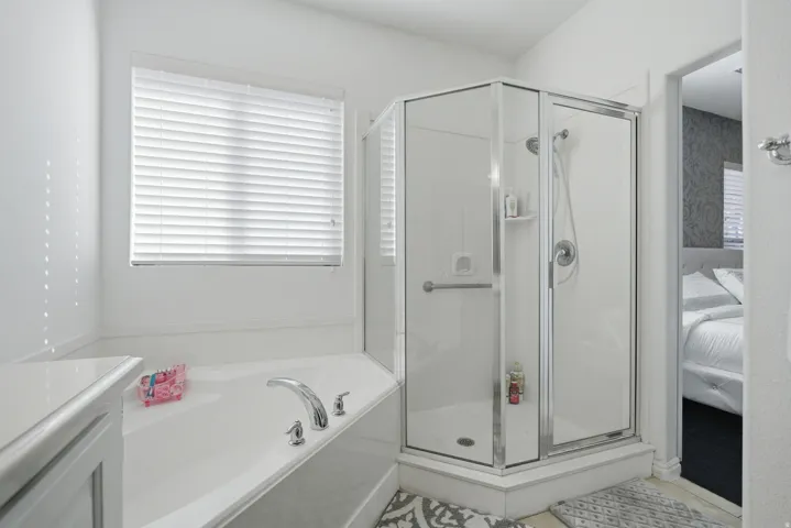 Ensuite bathroom with a stall shower, a garden tub, and vanity