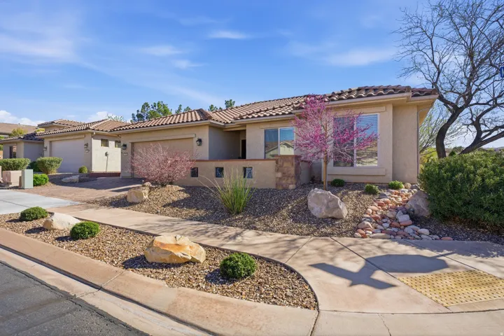Mediterranean / spanish home with stucco siding, driveway, an attached garage, and a tiled roof