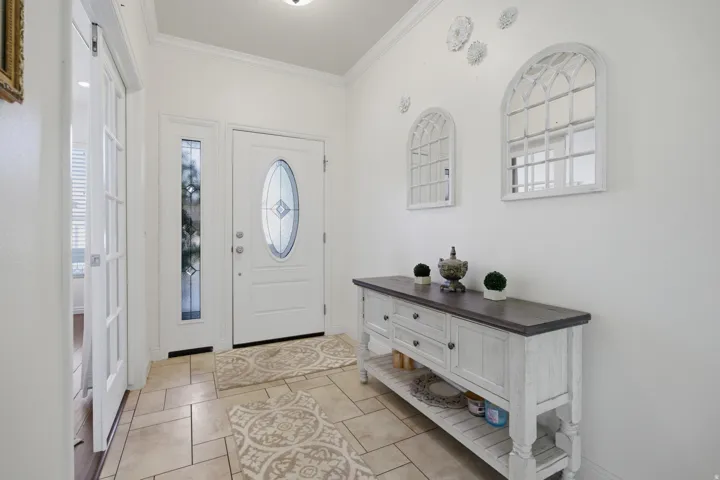 Foyer entrance with ornamental molding and baseboards