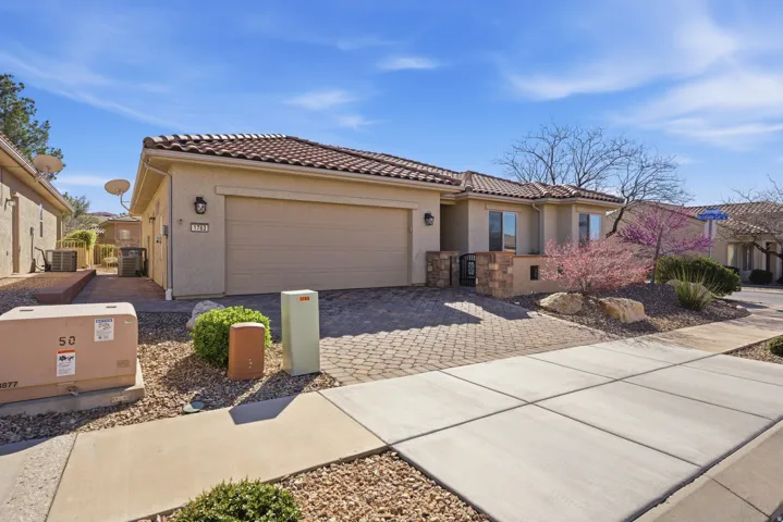 Mediterranean / spanish-style home featuring decorative driveway, an attached garage, stucco siding, and a tile roof