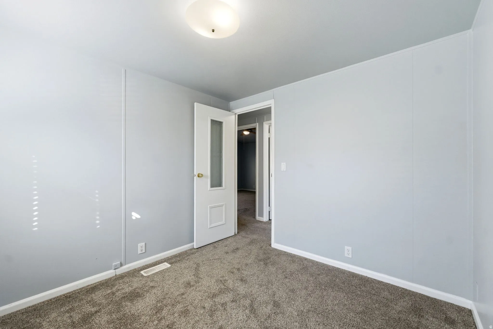 Unfurnished room with dark carpet and baseboards