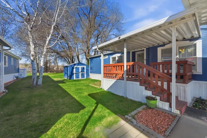Covered Deck. View of green lawn with a shed