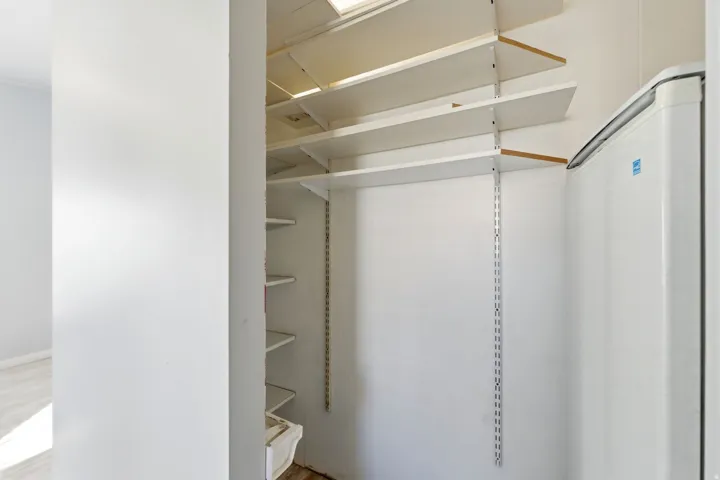 View of walk in closet, storage off Kitchen