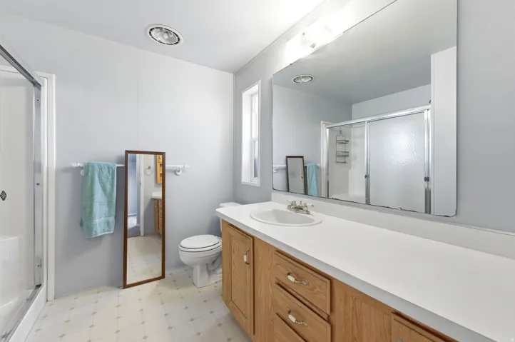 Full bathroom featuring light floors, vanity, and a stall shower