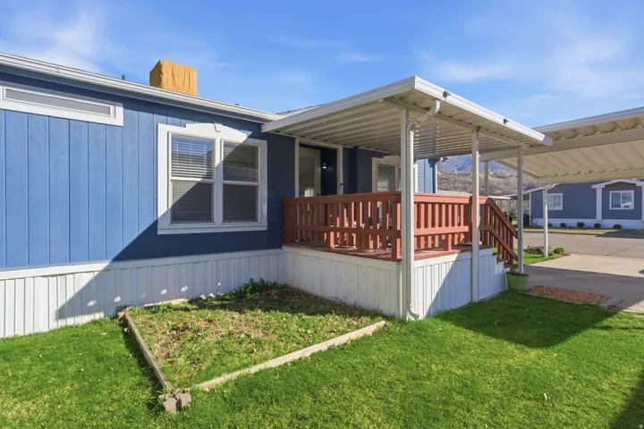 View of home's exterior featuring a lawn, a porch, and a chimney