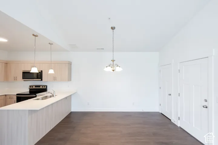 Open-concept living space with dark wood-finish flooring, white walls, and a vaulted ceiling