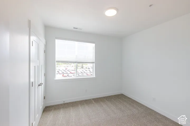 Window with blinds, flush mount ceiling lighting, white walls, white trim, and carpet flooring