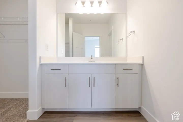 White vanity with brushed nickel hardware, integrated sink, and white countertop