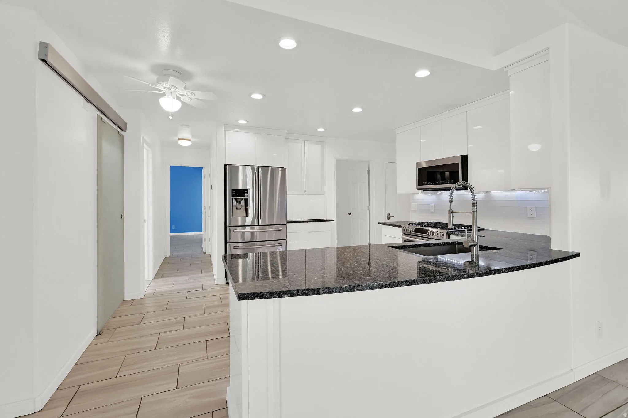 Kitchen with white cabinetry, dark stone countertops, tiled floors, recessed lighting, and a ceiling fan