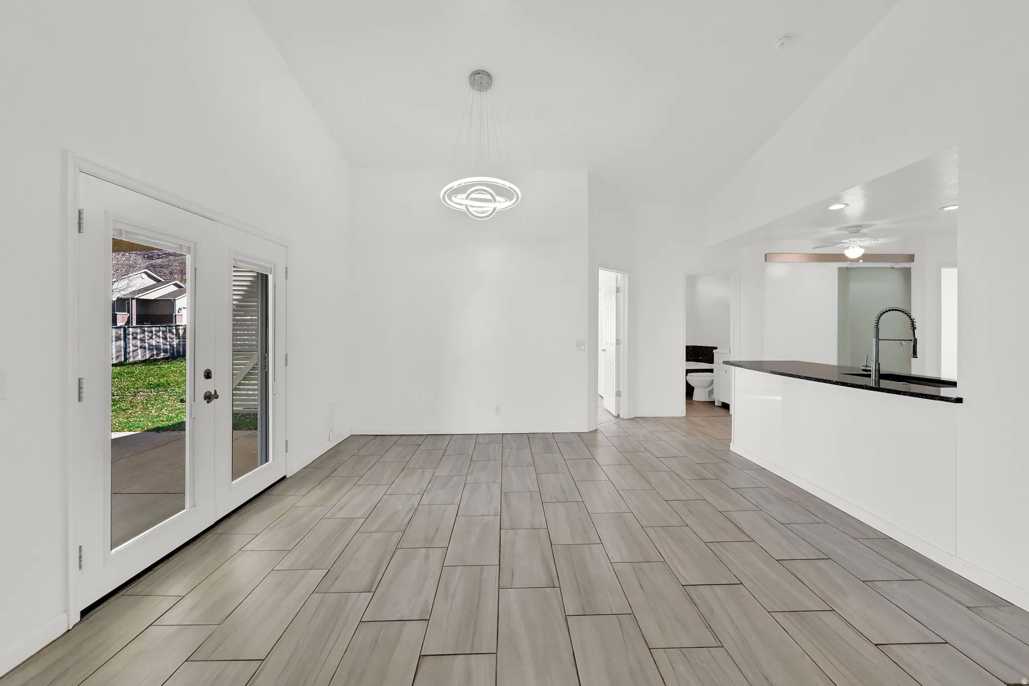 Dining area featuring vaulted ceiling, tile floors, and a ceiling fan