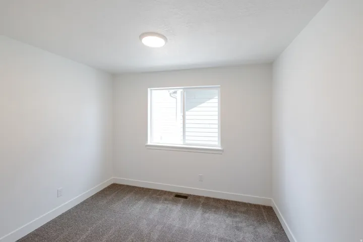 Neutral-toned room with plush carpeting and crisp white baseboards