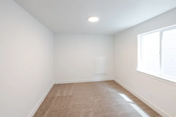 Room featuring light-colored walls and neutral-toned carpeting