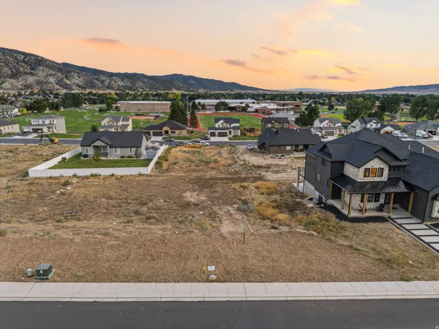 Expansive undeveloped lot with street frontage, mountain backdrop, and proximity to community green spaces