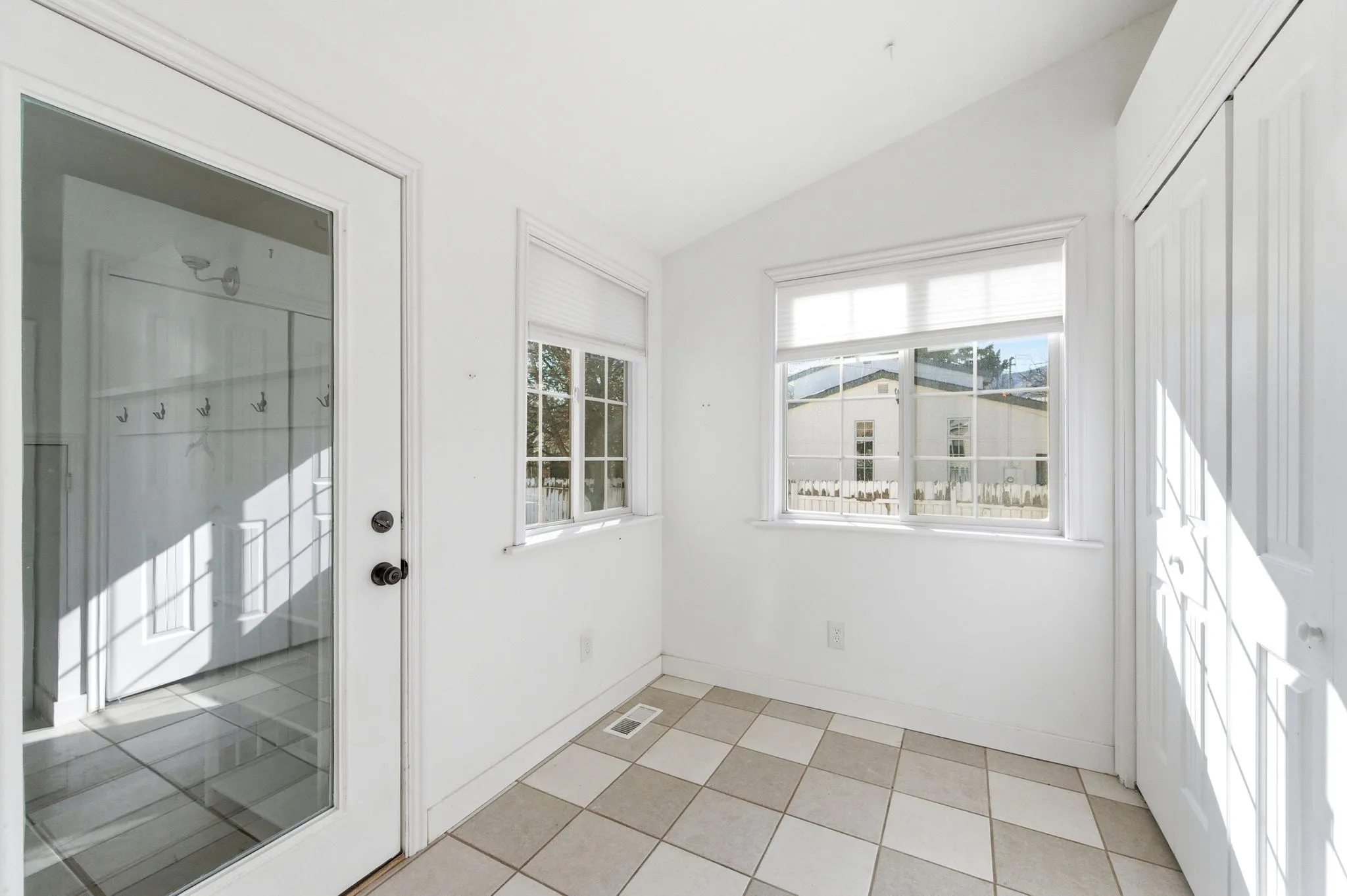 Doorway to outside featuring lofted ceiling and tile patterned floors
