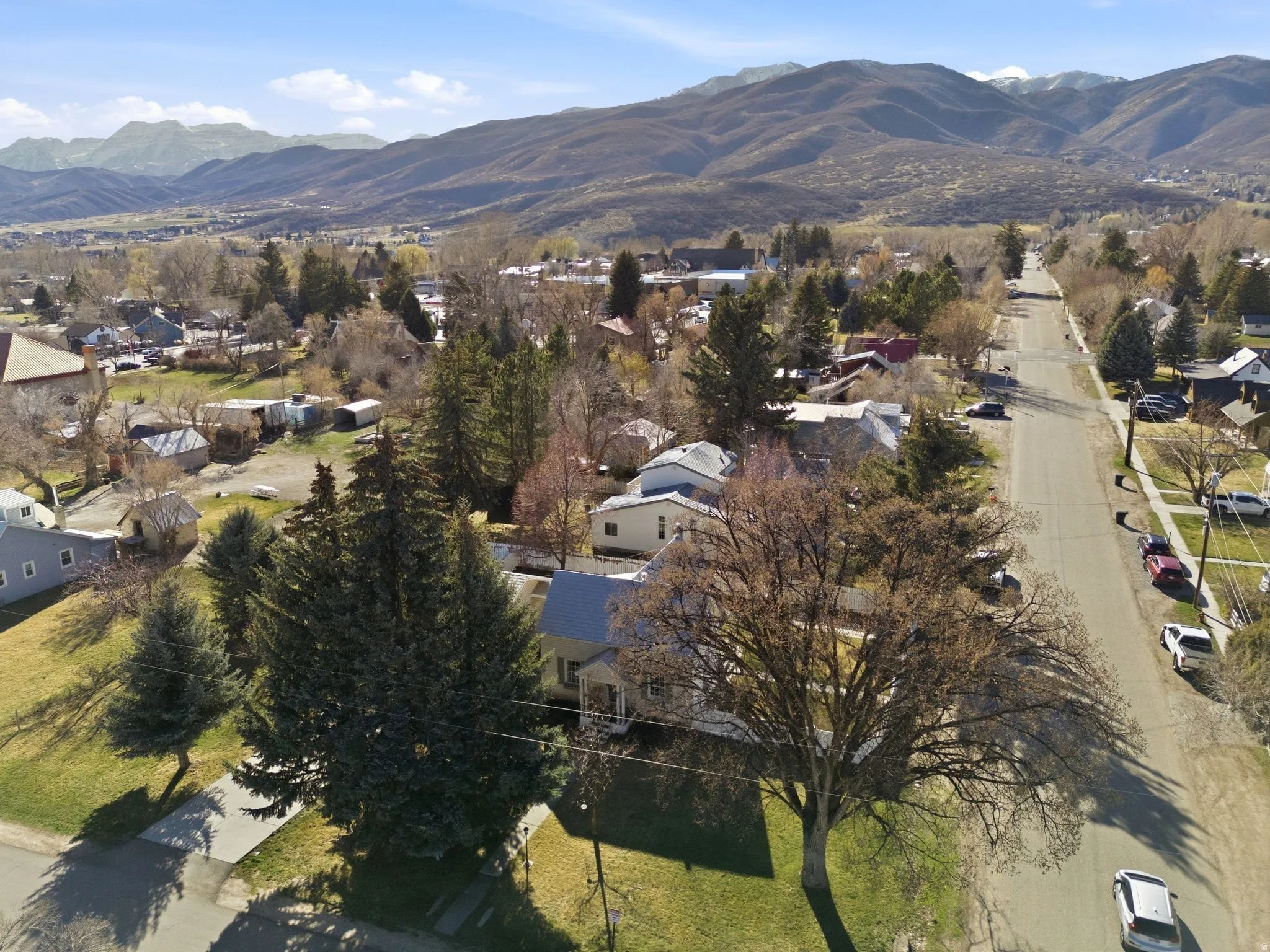 Aerial view of property and surrounding area featuring a mountain backdrop and nearby suburban area