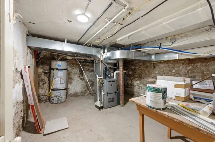 Unfinished below grade area with strapped water heater and heating unit