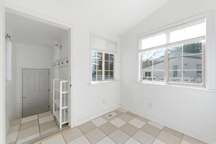 Spare room featuring lofted ceiling and light tile patterned floors