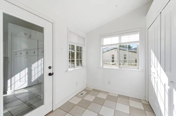 Doorway to outside featuring lofted ceiling and tile patterned floors