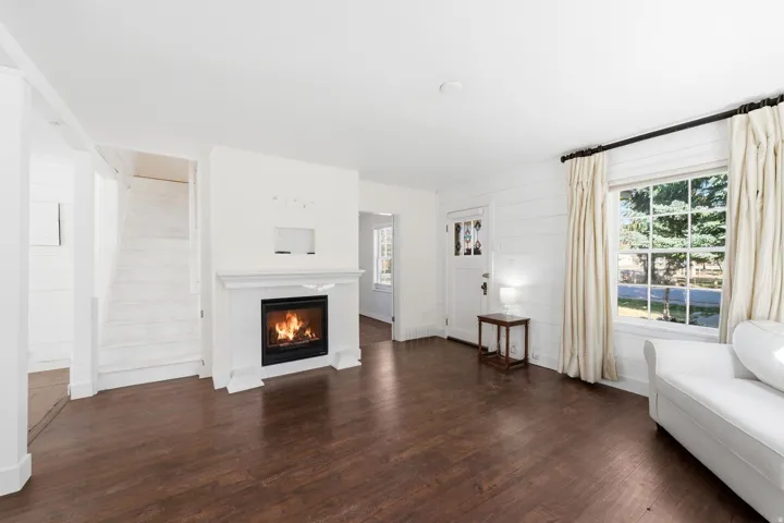 Living area with dark wood-style flooring and a glass covered fireplace