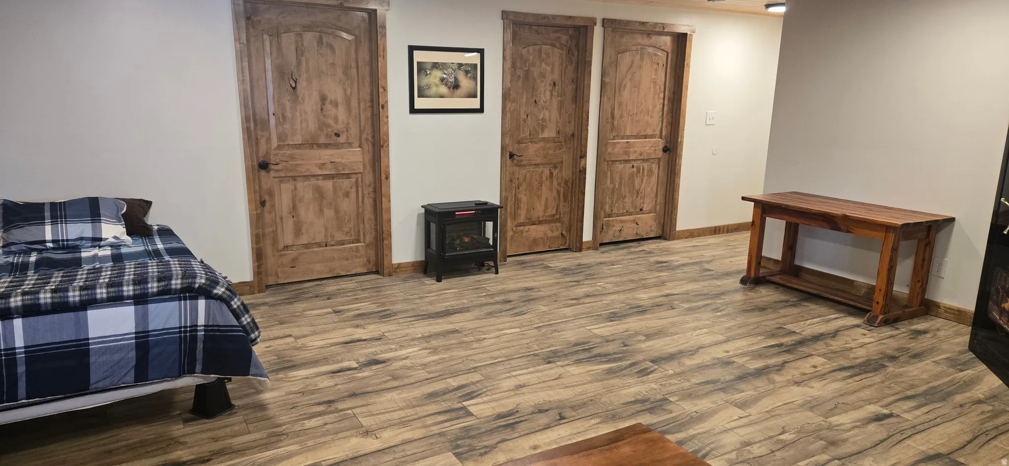 Bedroom featuring dark wood-type flooring and a wood stove